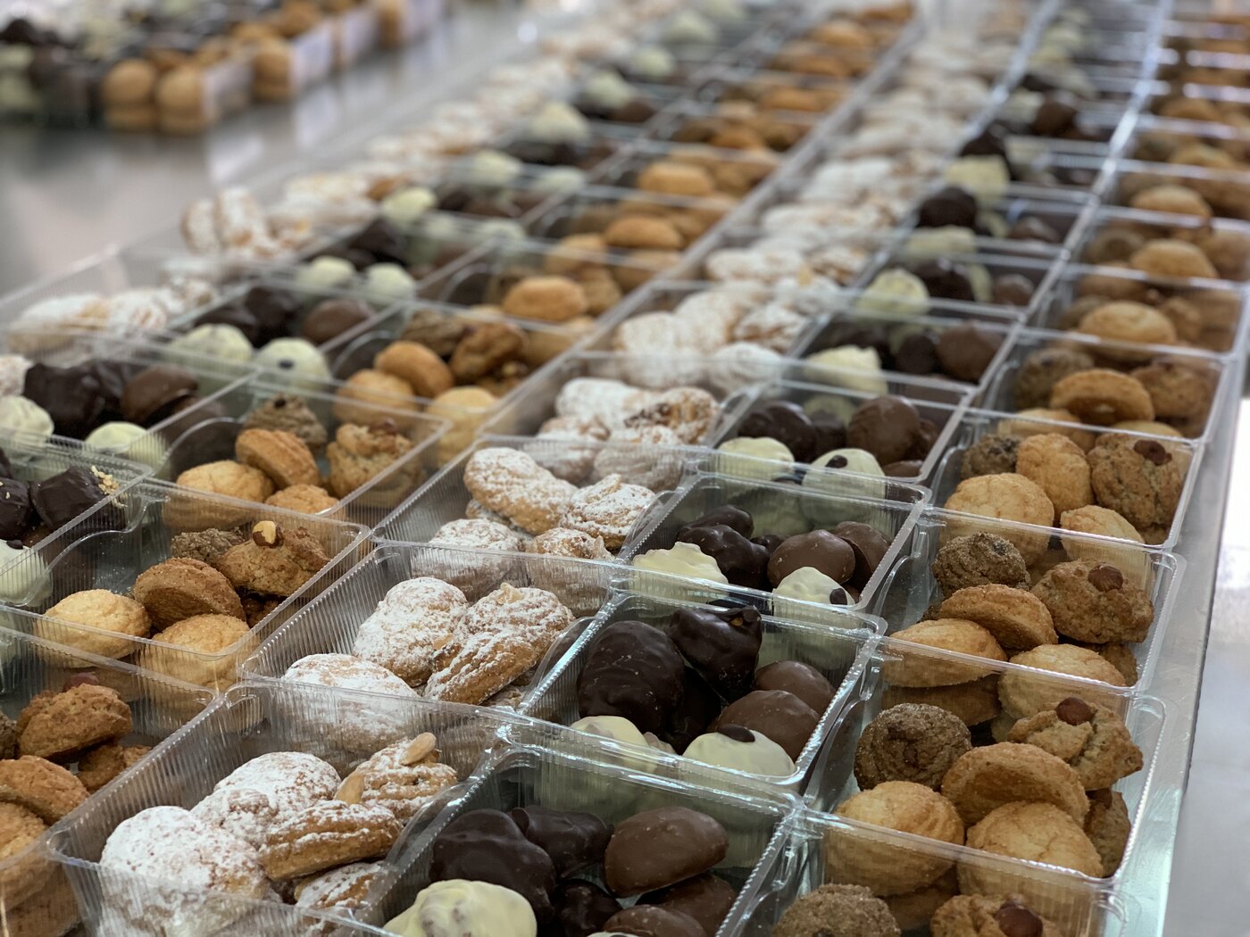 Trays of assorted almond and hazelnut pastries being prepared